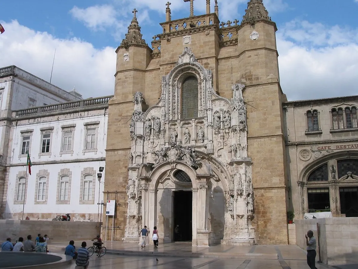 Coimbra Baixa lower town streetscape with traditional buildings and the Santa Cruz Monastery facade in the background