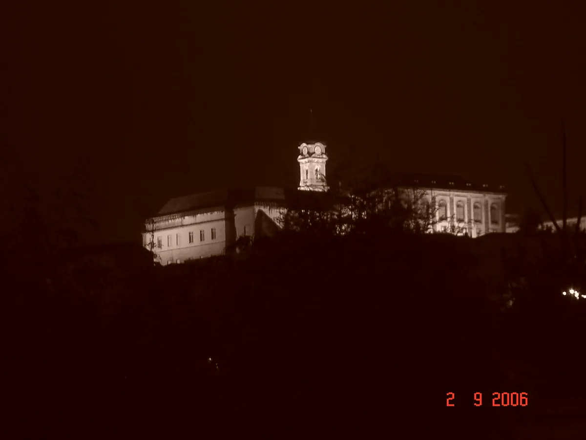 Historic University of Coimbra buildings rising above terracotta rooftops with sweeping Coimbra cityscape below