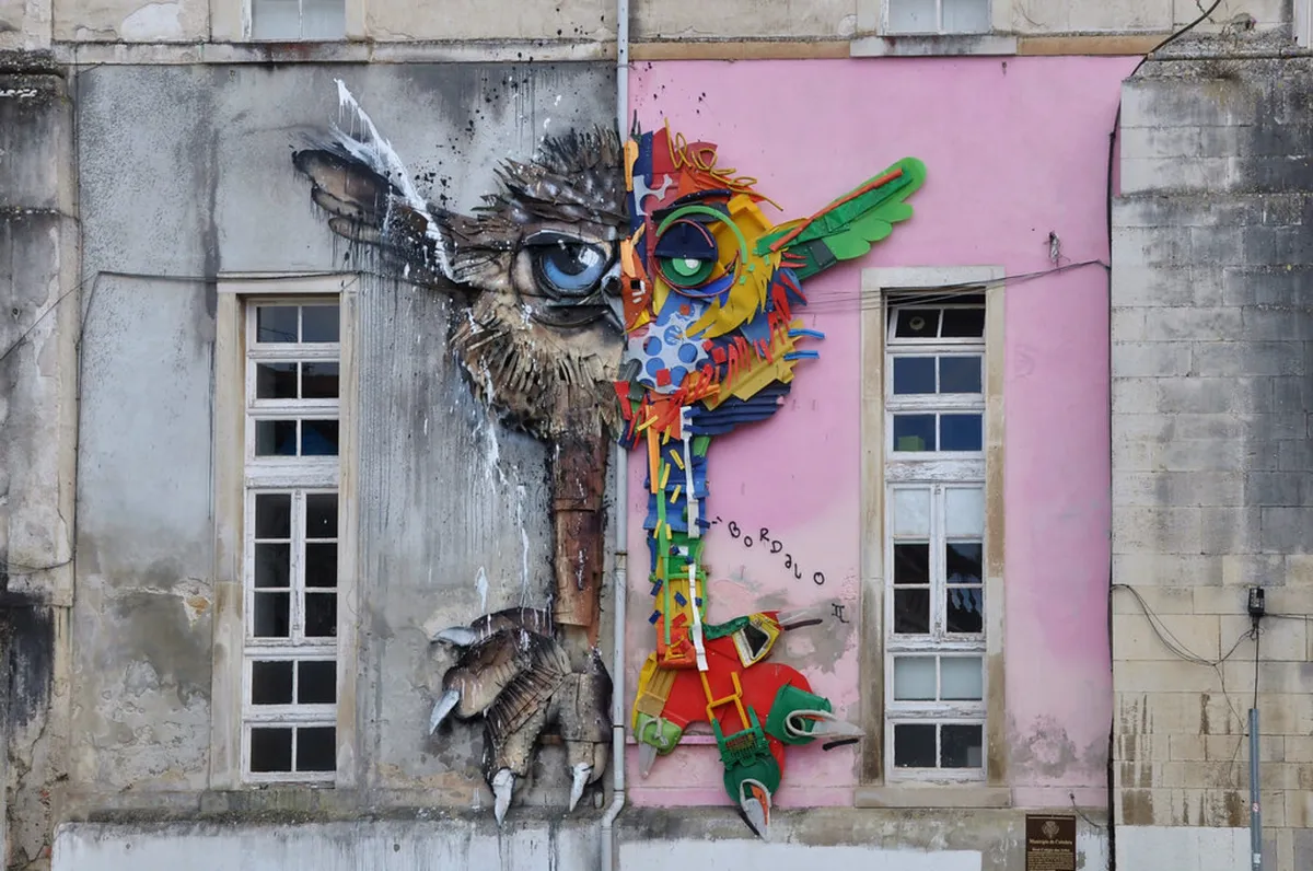 Colorful street art mural on a building wall in Coimbra, Portugal, by a local urban artist