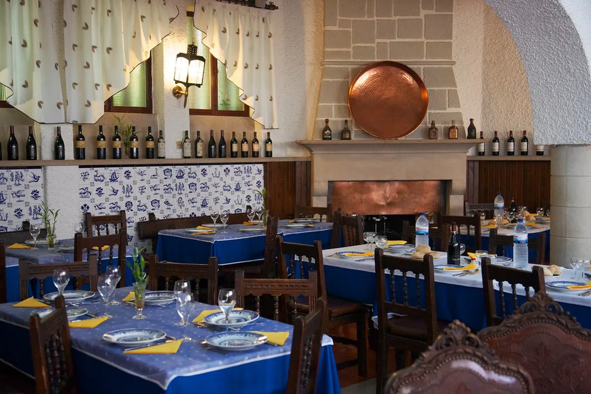 Traditional tasca interior in Coimbra with wooden tables and a chalkboard menu offering authentic Portuguese dishes