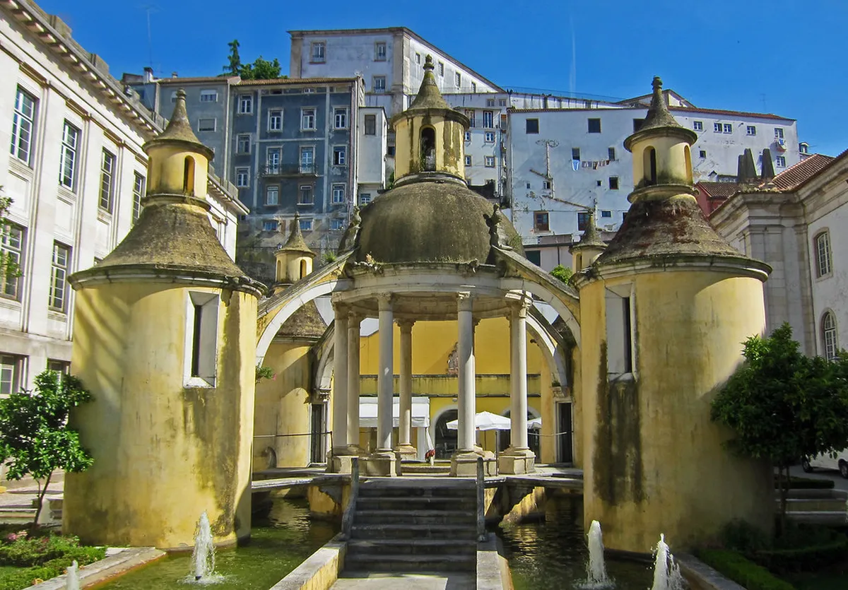 Jardim da Manga's circular Renaissance fountain surrounded by lush greenery in Coimbra, Portugal