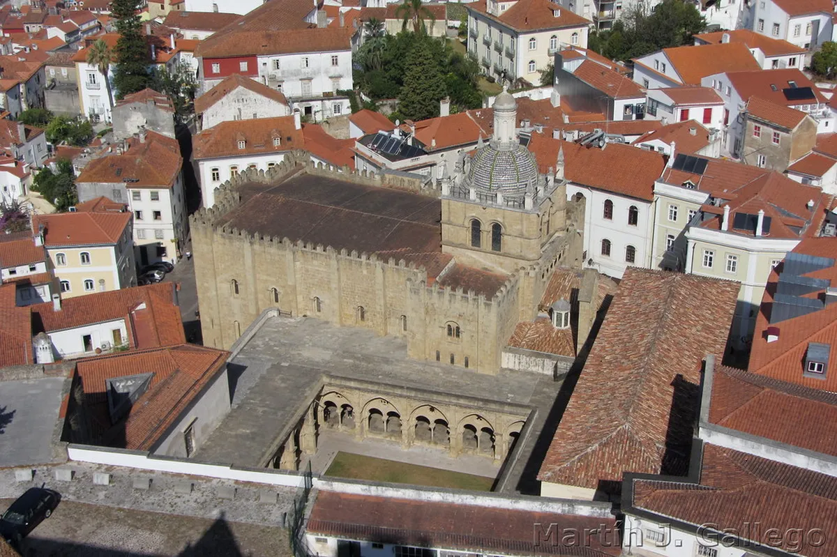 Coimbra Sé Velha Romanesque cathedral facade with ornate portal on a historic cobblestone street