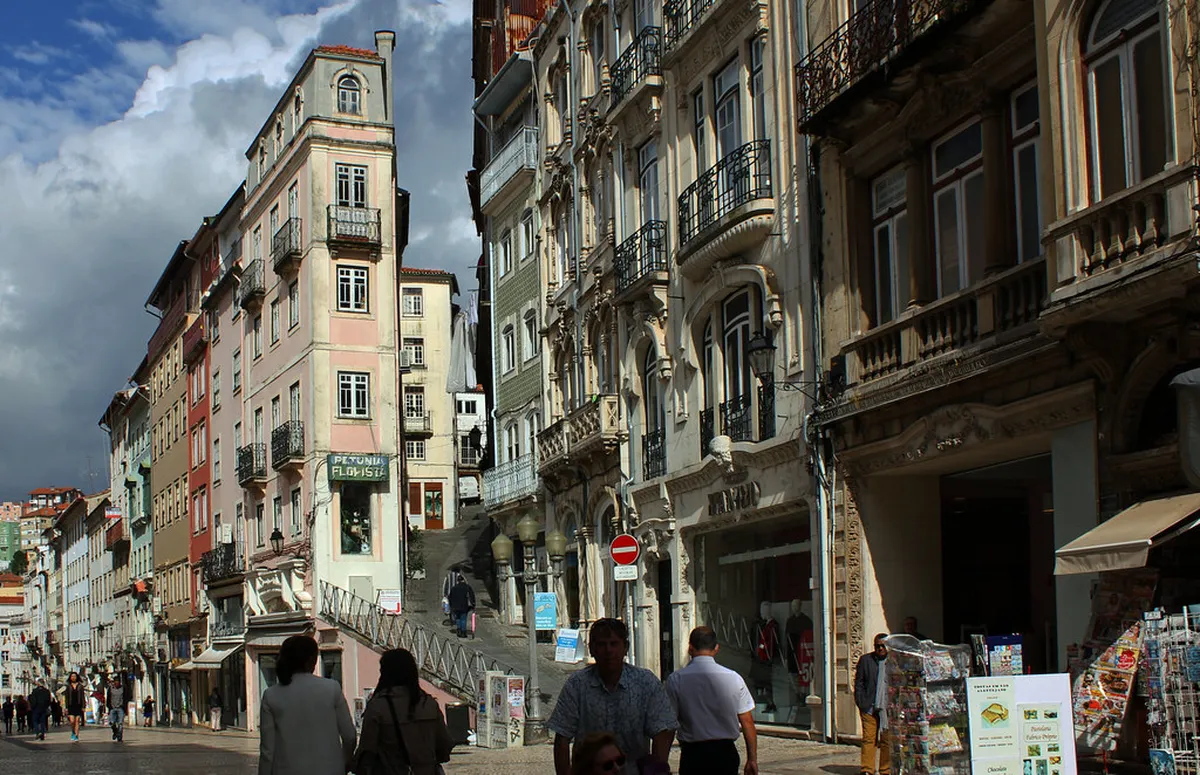 Narrow winding medieval streets in Coimbra lined with traditional Portuguese architecture and stone pavements