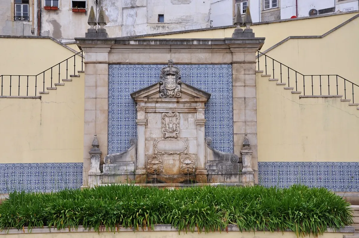 Quiet alley in the historic Jewish Quarter of Coimbra with worn stone walls and traditional architecture lining the passage