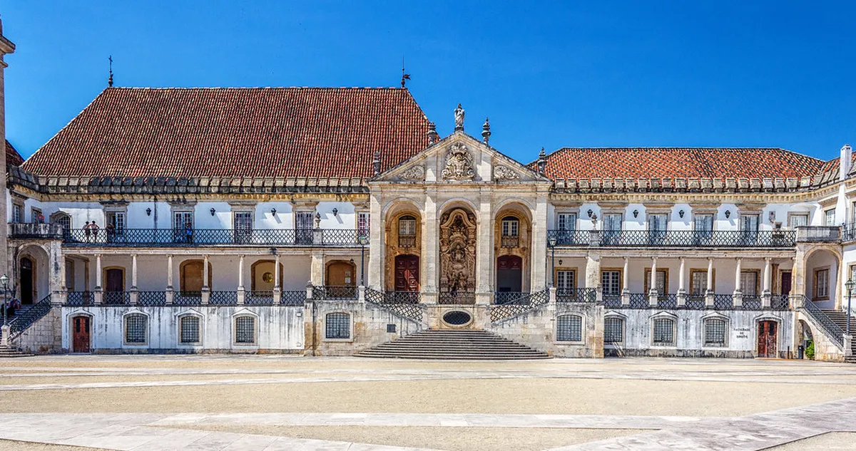 University of Coimbra hilltop campus overlooking the city with ornate baroque tower and terracotta rooftops in Coimbra