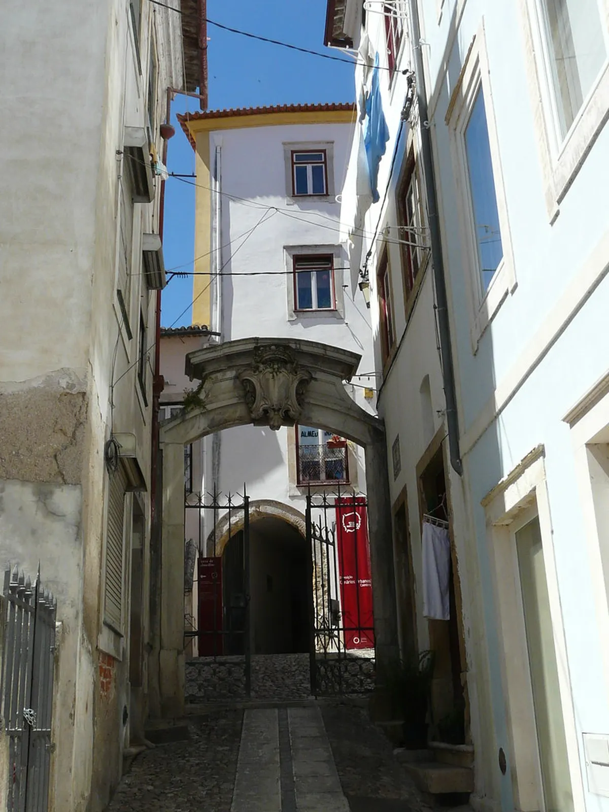 Coimbra street scene with colorful tiled facades and pedestrians walking through a traditional Portuguese neighborhood