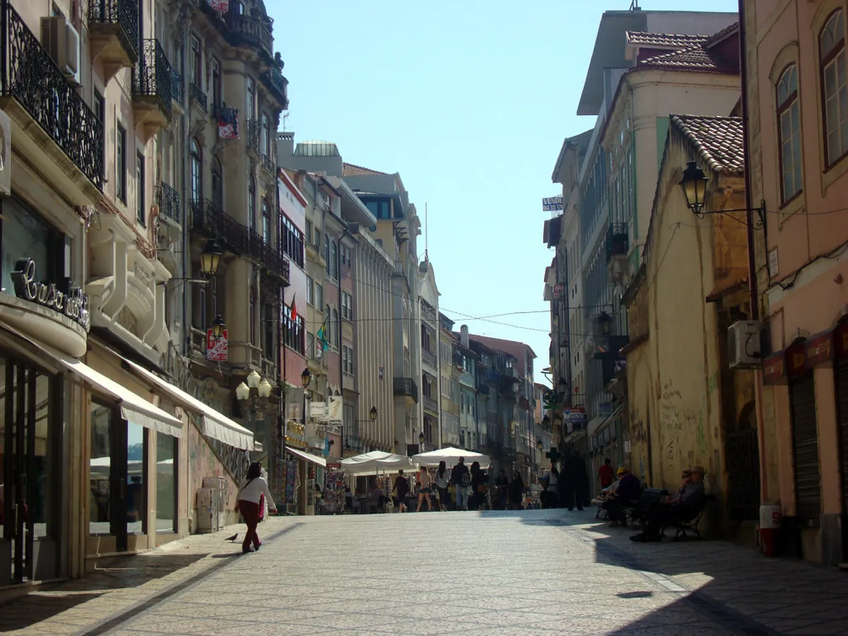 Coimbra Baixa street scene with colourful buildings and pedestrians exploring the lower town