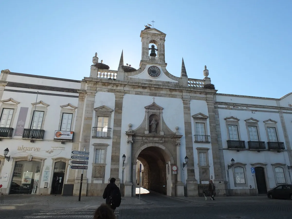 Neoclassical stonework and ornate archway of the Arco da Vila entrance in Faro's historic district