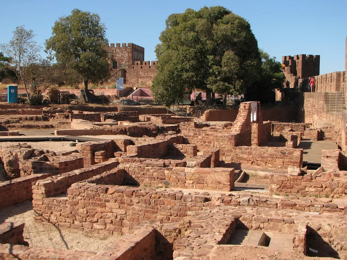 Red sandstone walls of Silves Castle rising above the Algarve hillside, a top historic day trip from Faro