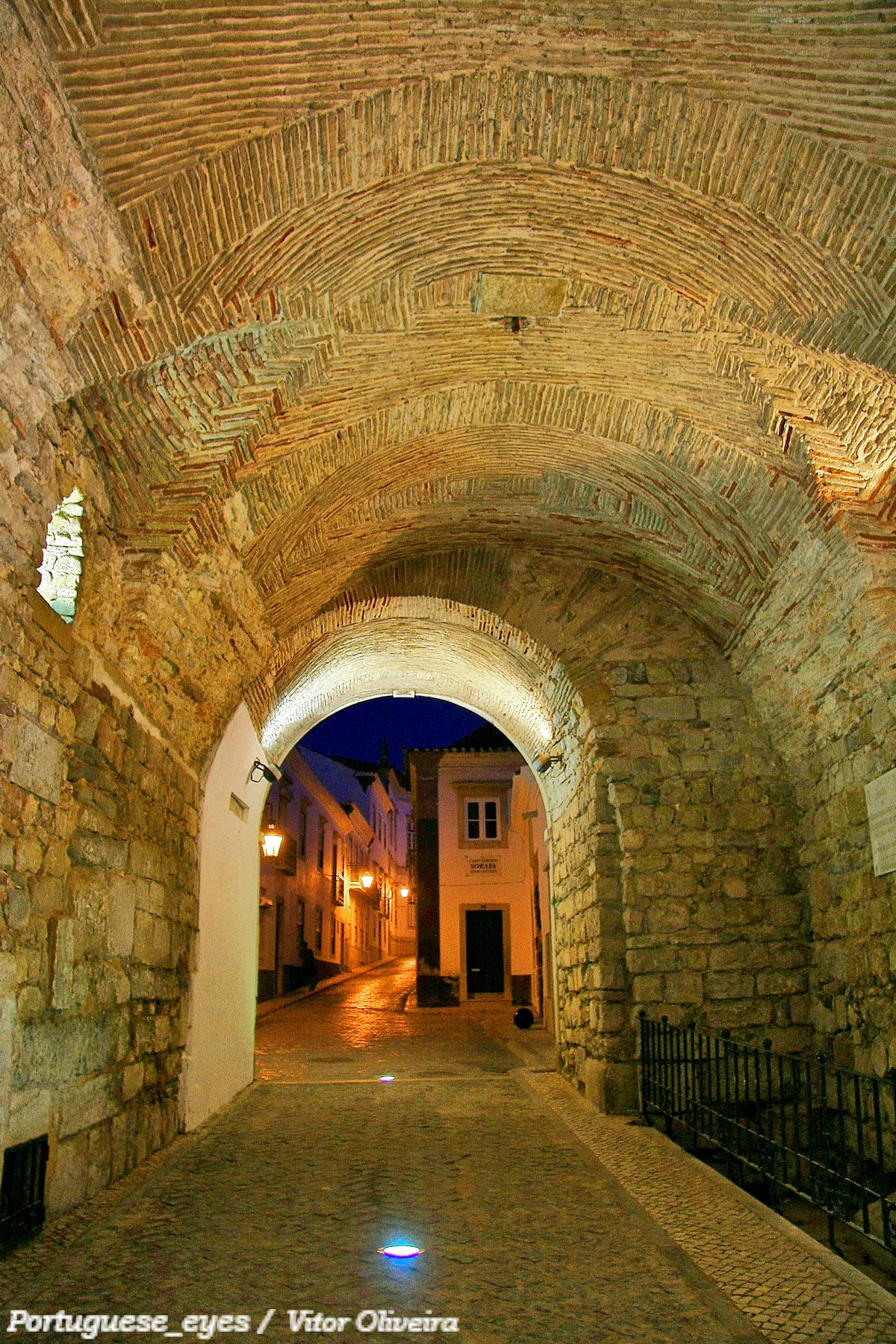The historic Arco da Vila gateway leading into Faro Old Town, framed by centuries-old stone archwork