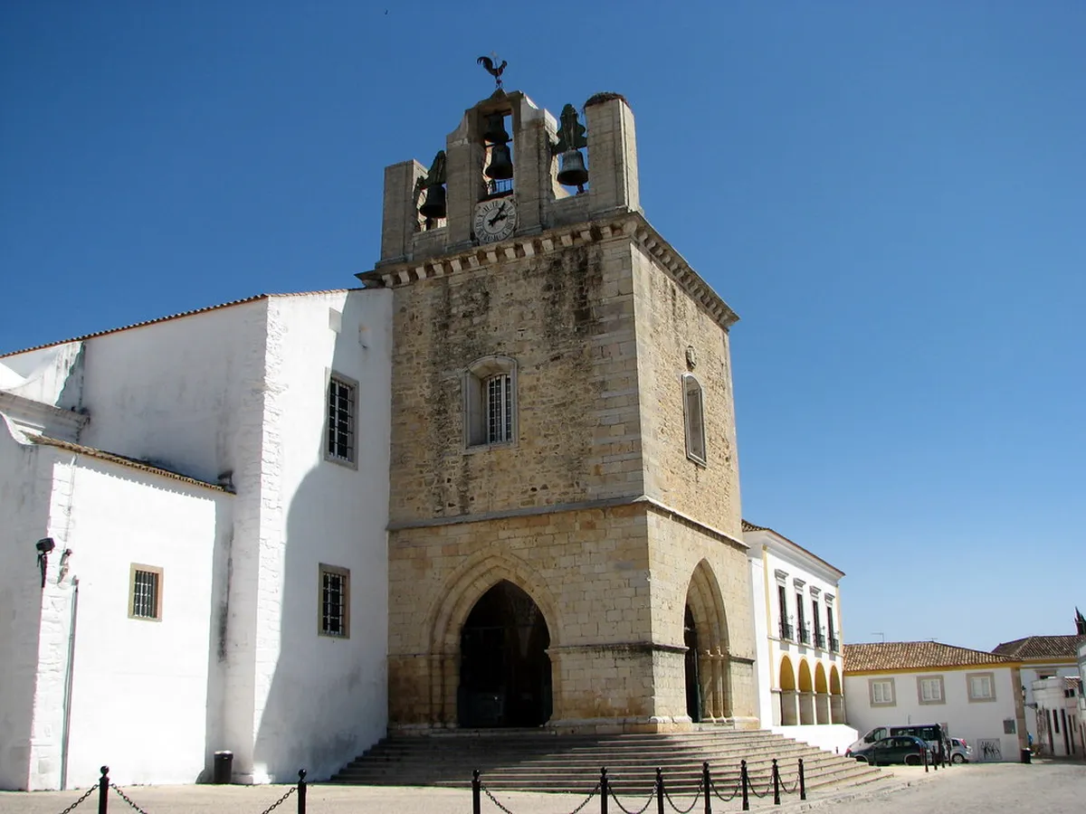 Sunlit Largo da Sé square in Faro framed by the historic cathedral and palms on a clear day