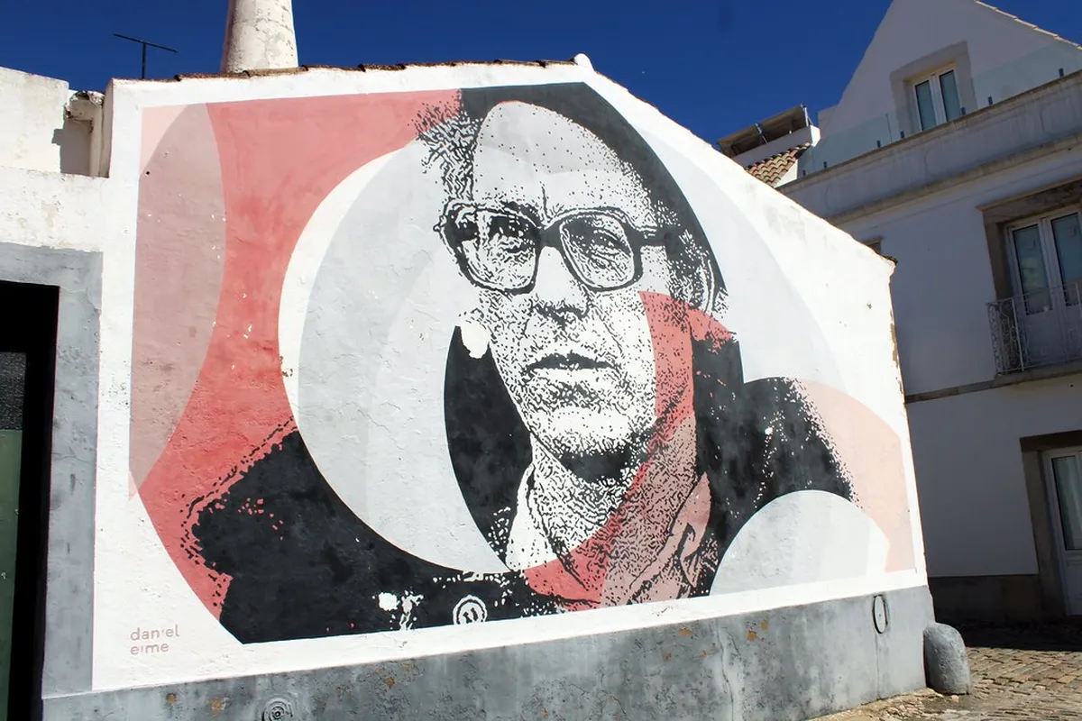 Colorful street art mural on a building wall near the Arco da Vila gate in Faro's historic center