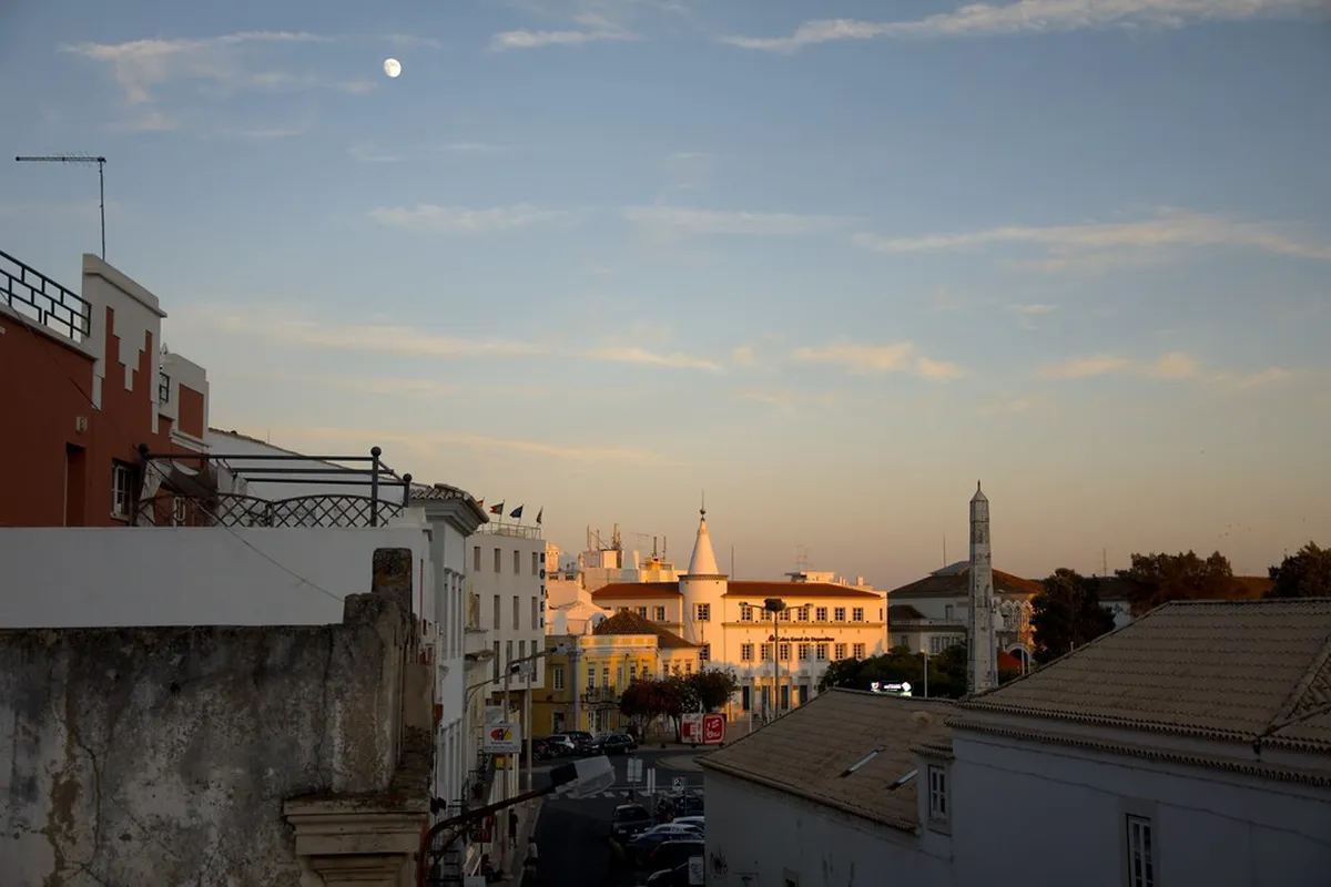 Golden sunset light washing over Faro old town rooftops and the Ria Formosa lagoon below