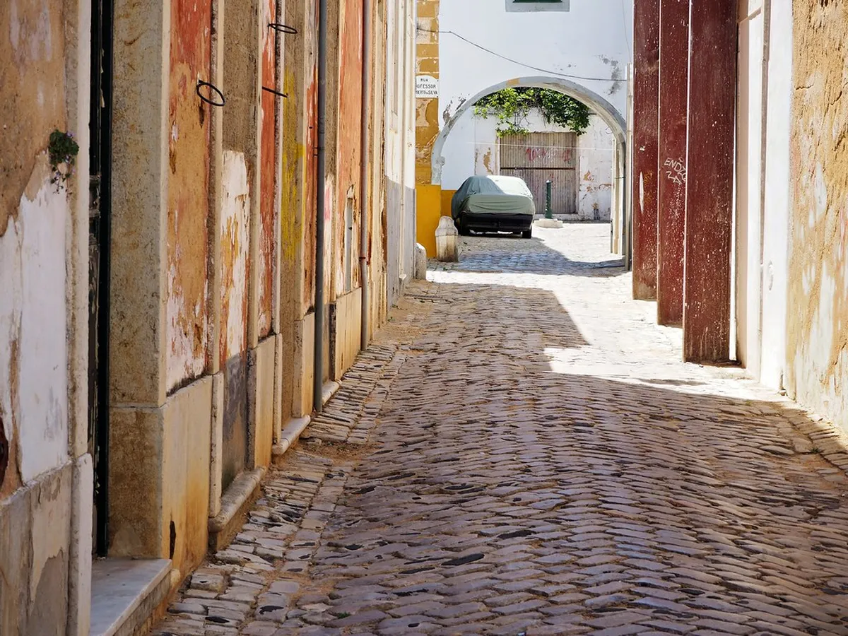 Cobblestone street in Faro Portugal lined with traditional whitewashed buildings perfect for a leisurely walk