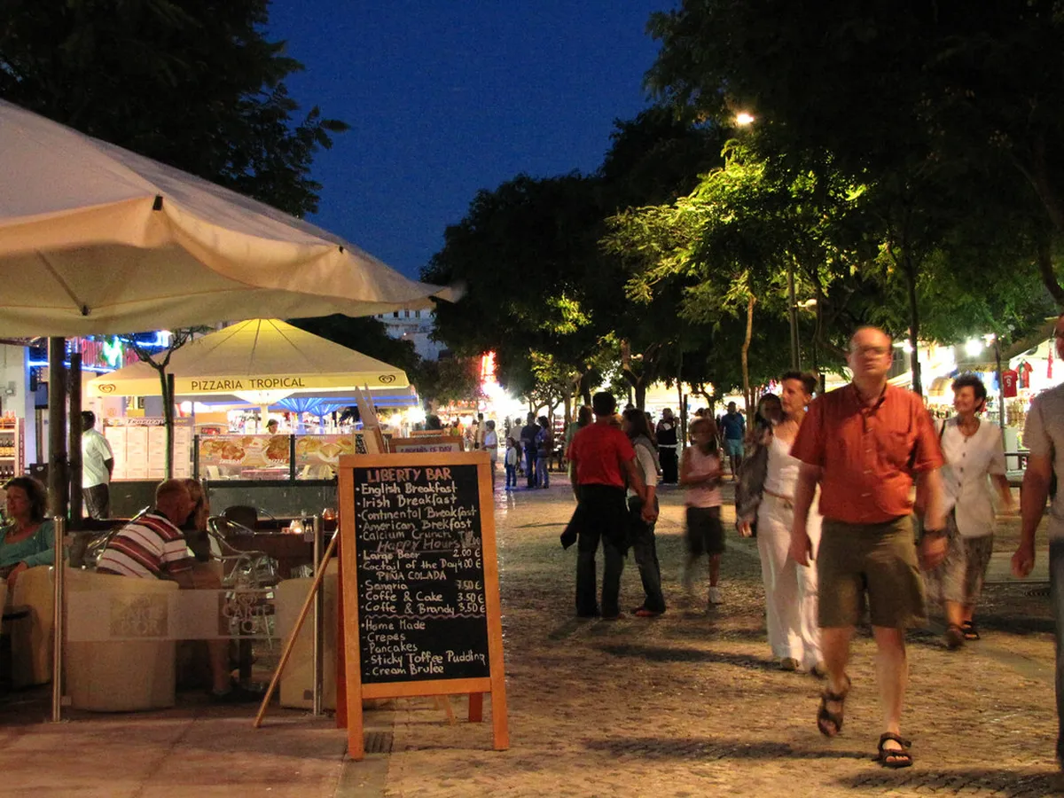 Outdoor cafe seating along a Faro street with tables on a pedestrian area near the historic center