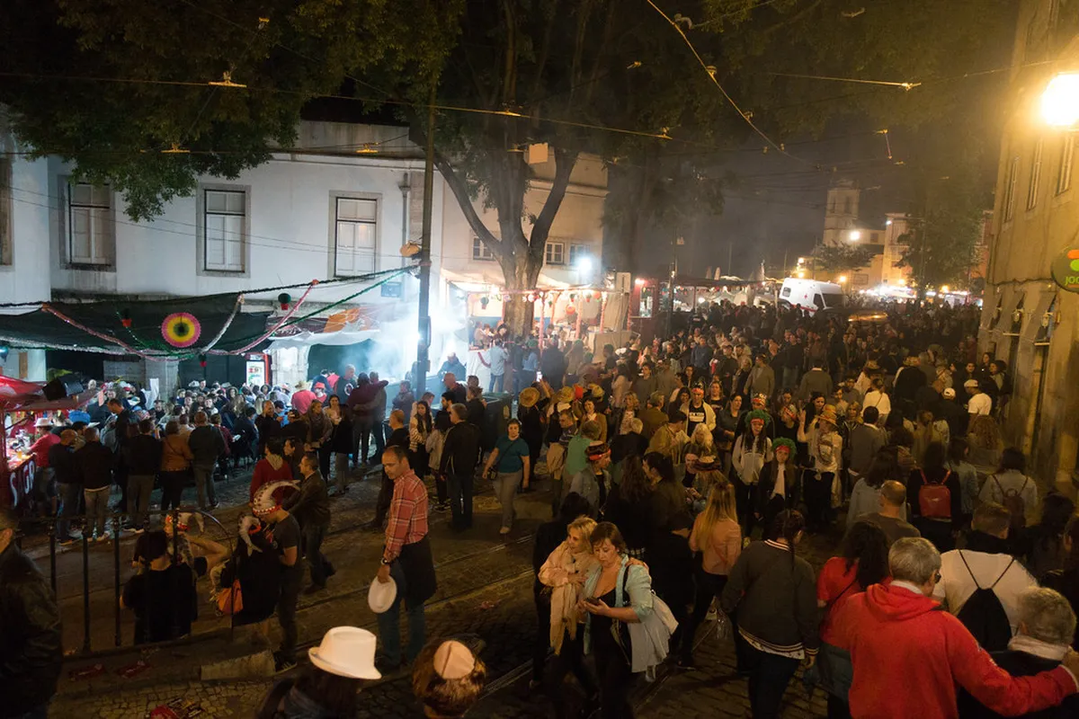 Festive arraiais street party in Lisbon with crowds celebrating the Santo António festival at night