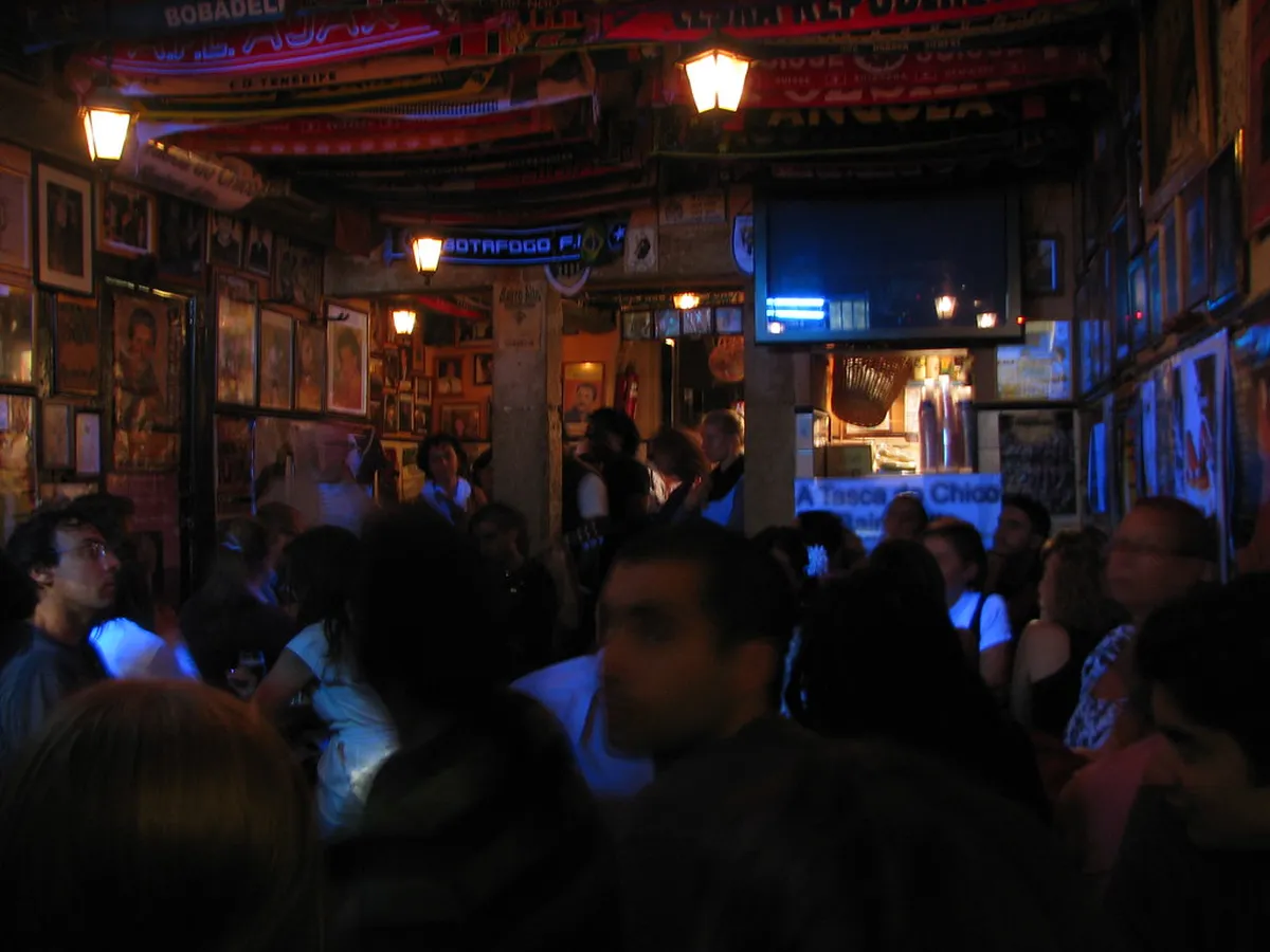 Lisbon fado venue at night with traditional Portuguese guitarra and singer performing for a seated audience