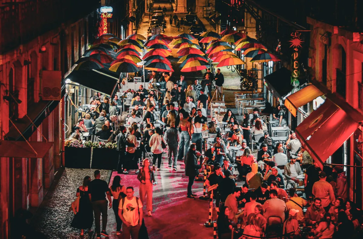 Lisbon Pink Street at Cais do Sodré lit up at night with crowds enjoying the late-night club scene
