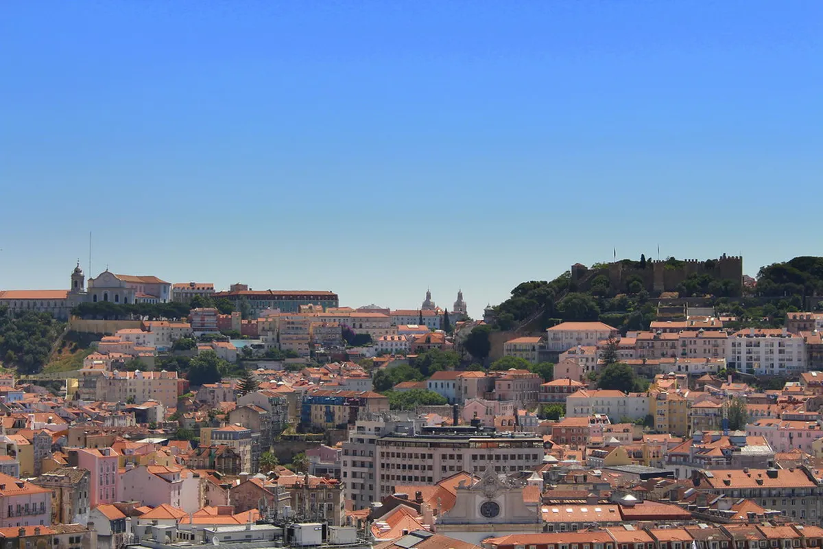Panoramic view from Lisbon’s Miradouro de São Pedro de Alcântara over the Baixa district and the Tagus river at sunset