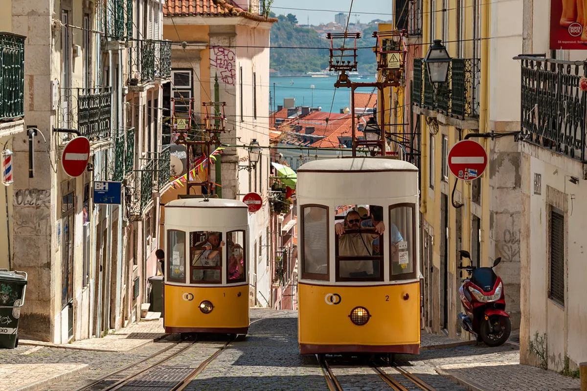 Lisbon Elevador da Bica yellow vintage funicular tram climbing the steep hillside street
