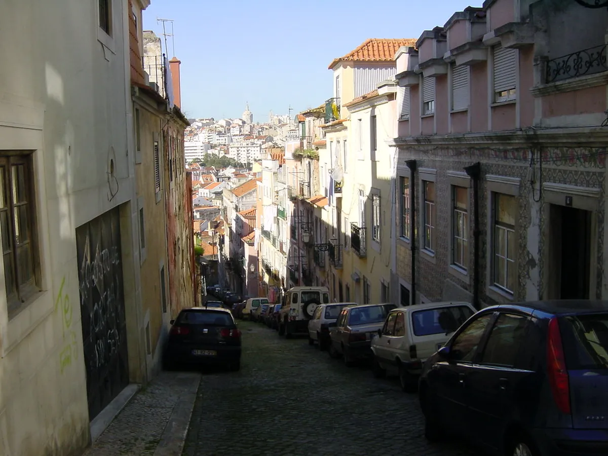 Narrow cobblestone street in Lisbon's Bairro Alto historic quarter with traditional tiled facades