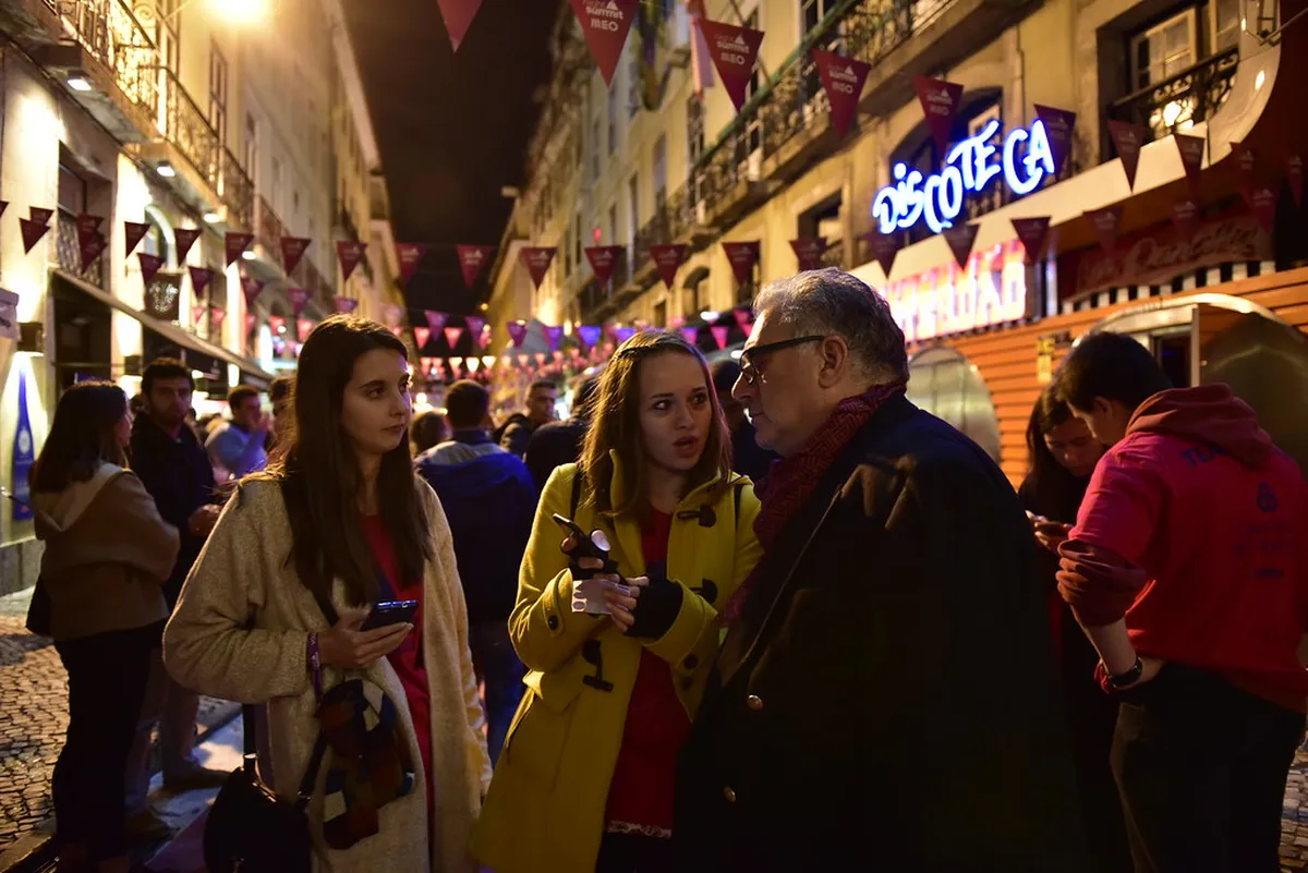 Lisbon Cais do Sodré Pink Street with neon lights and crowds on a vibrant evening