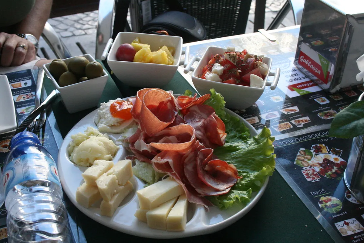 Traditional Lisbon petiscos spread of small Portuguese dishes including cod fritters and local wine