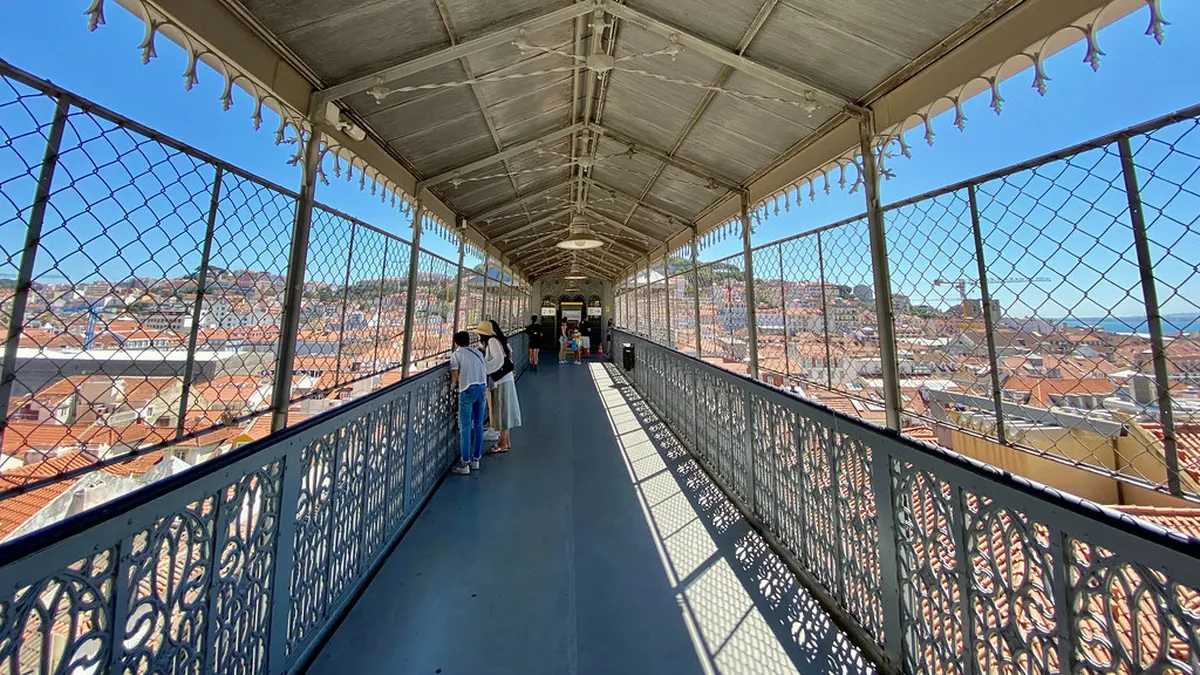 The Santa Justa Elevator's ornate neo-Gothic ironwork tower rising above the rooftops of Lisbon's Baixa district