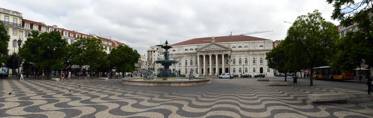 Lisbon Rossio Square bustling with visitors surrounded by historic Pombaline buildings and ornate fountain