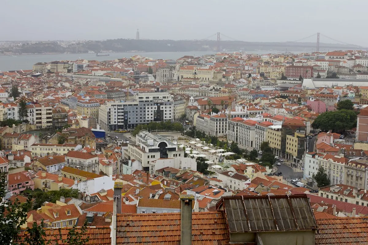 Sweeping Lisbon cityscape seen from Miradouro da Senhora do Monte in Graca with the castle and river