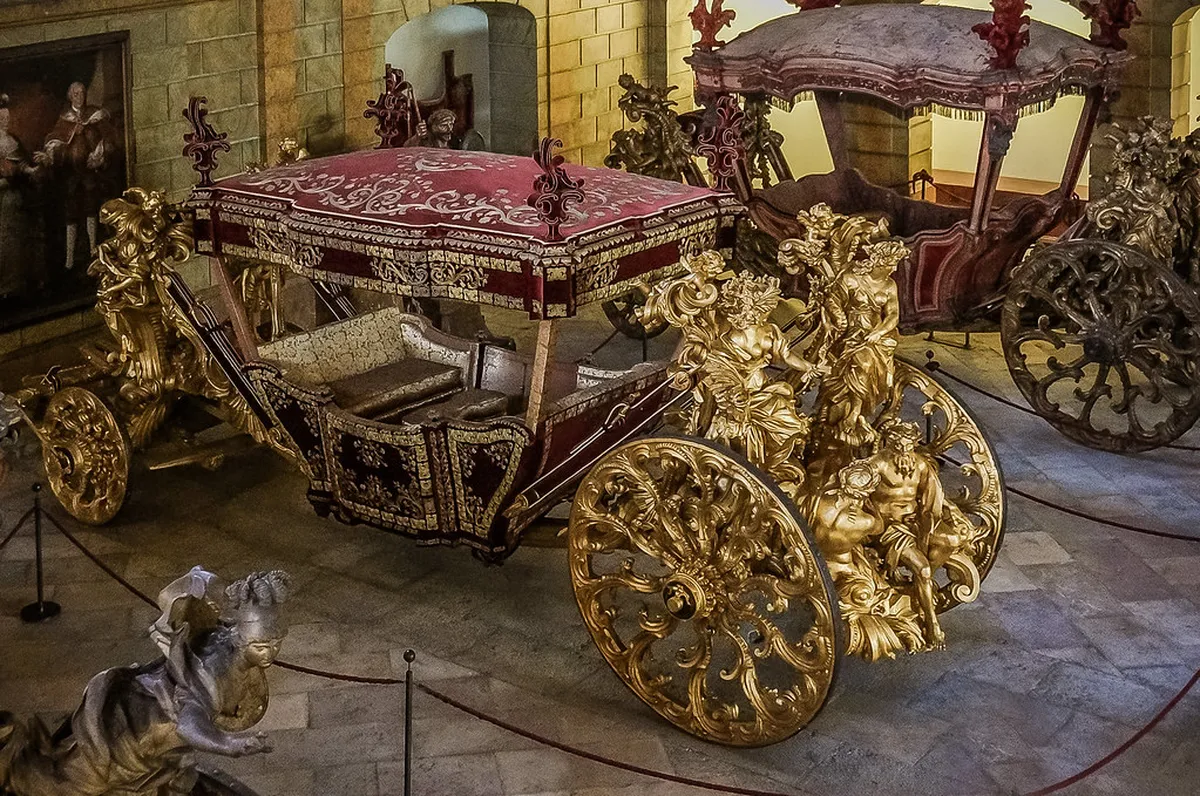 Ornate gilded royal coaches on display inside the National Coach Museum in Belém, Lisbon
