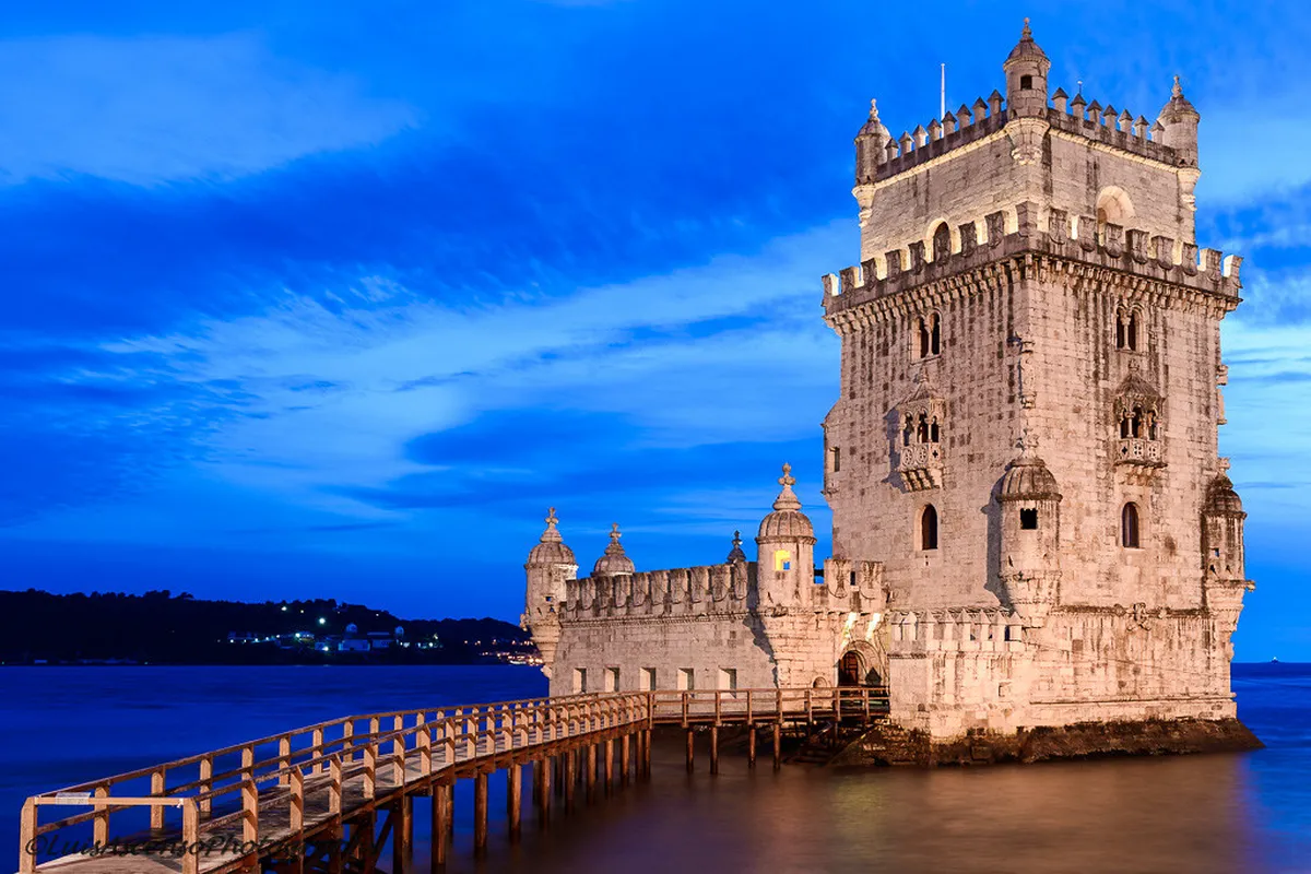 Lisbon Belem Tower standing on the Tagus River waterfront with ornate Manueline stone carvings at golden hour