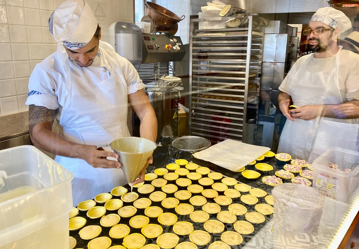 Artisan pastry display at a Lisbon neighbourhood bakery, showcasing freshly baked pasteis de nata