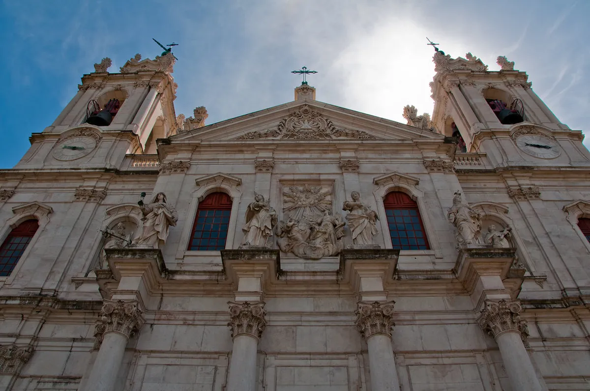Lisbon Estrela Basilica baroque facade rising above a quiet square on a sunny afternoon