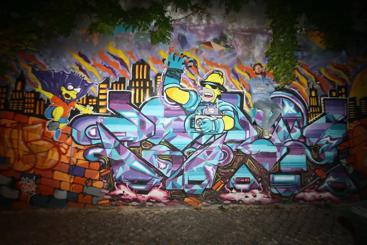 Colorful street art mural on building wall during a guided Lisbon street art tour