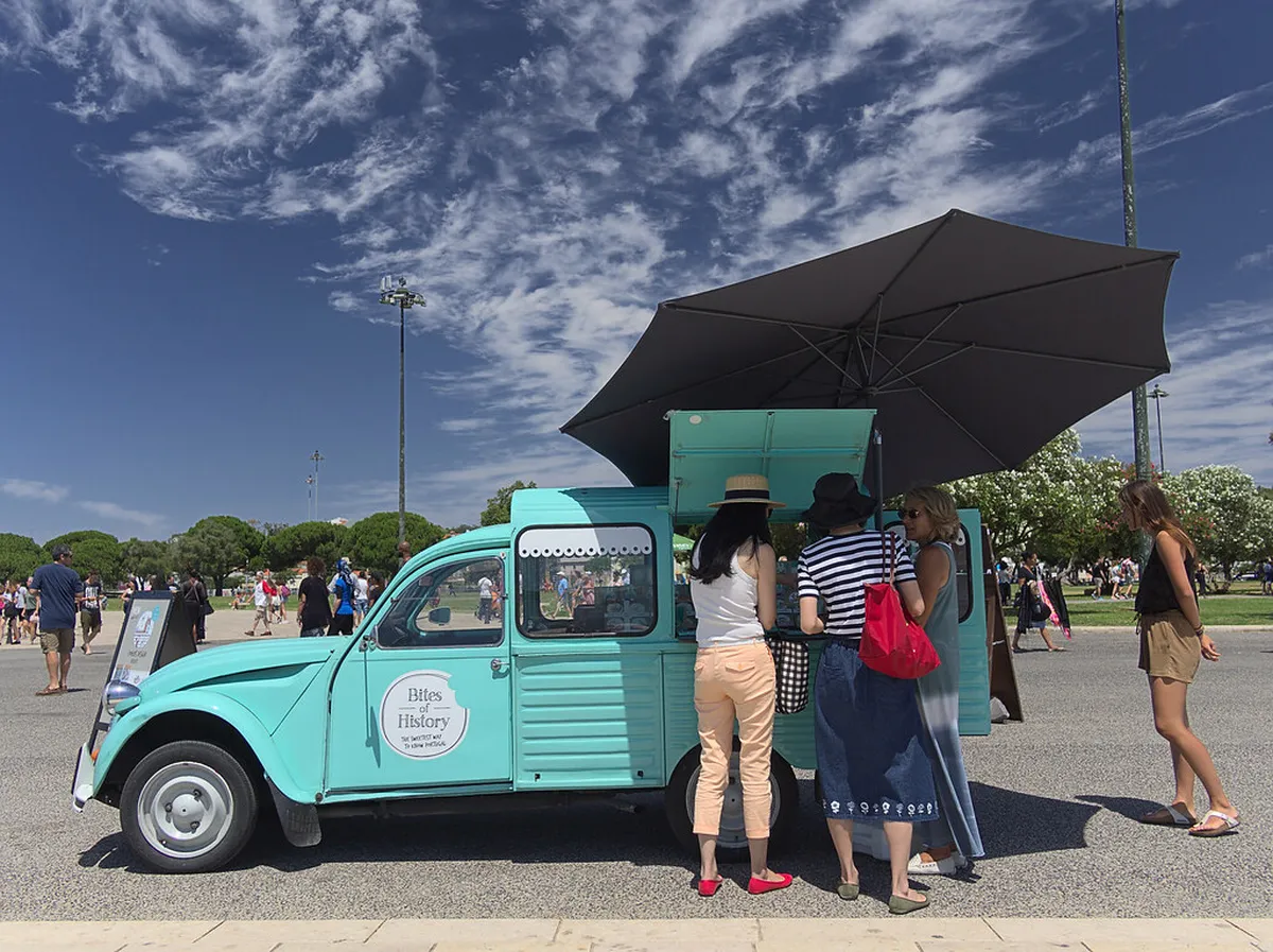 Colorful Lisbon street food stalls in a bustling market with local vendors and fresh Portuguese snacks