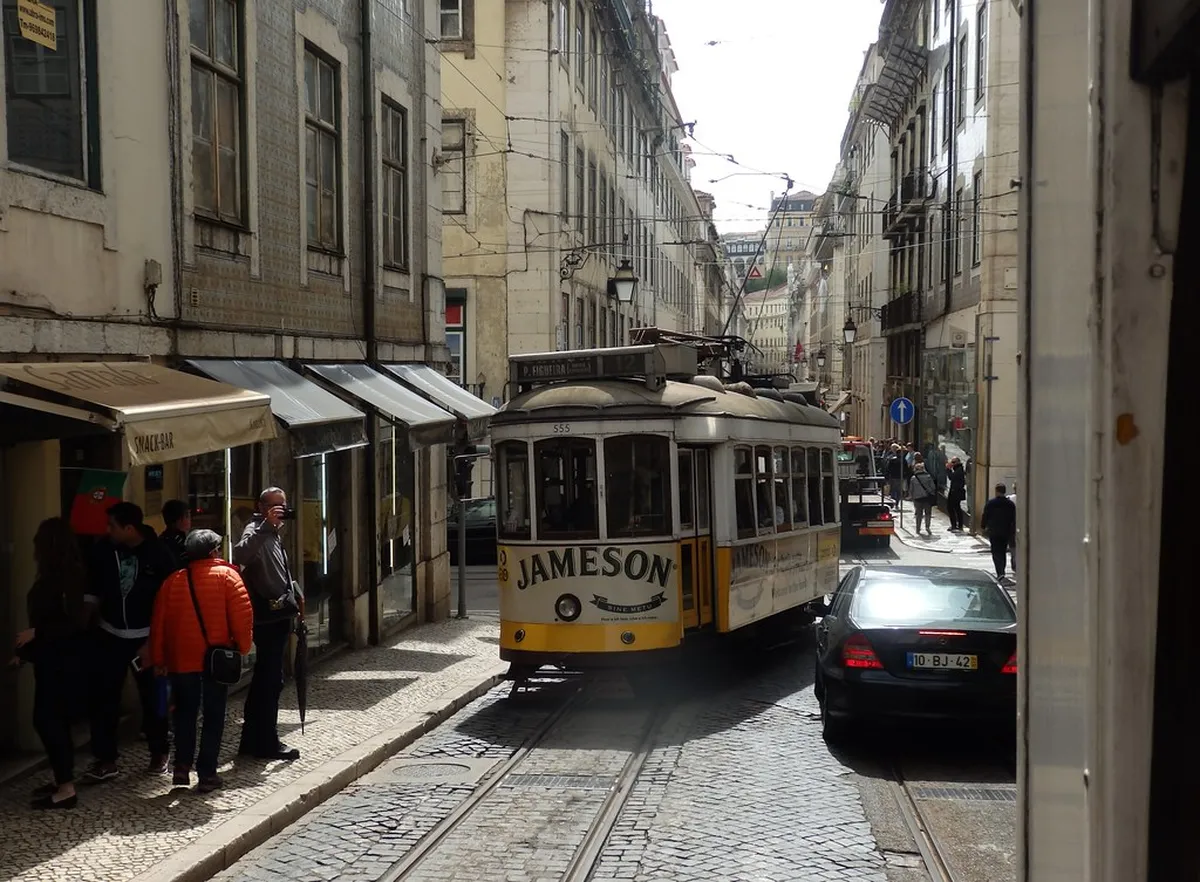 Iconic yellow Lisbon tram at a stop in the Baixa district surrounded by historic architecture
