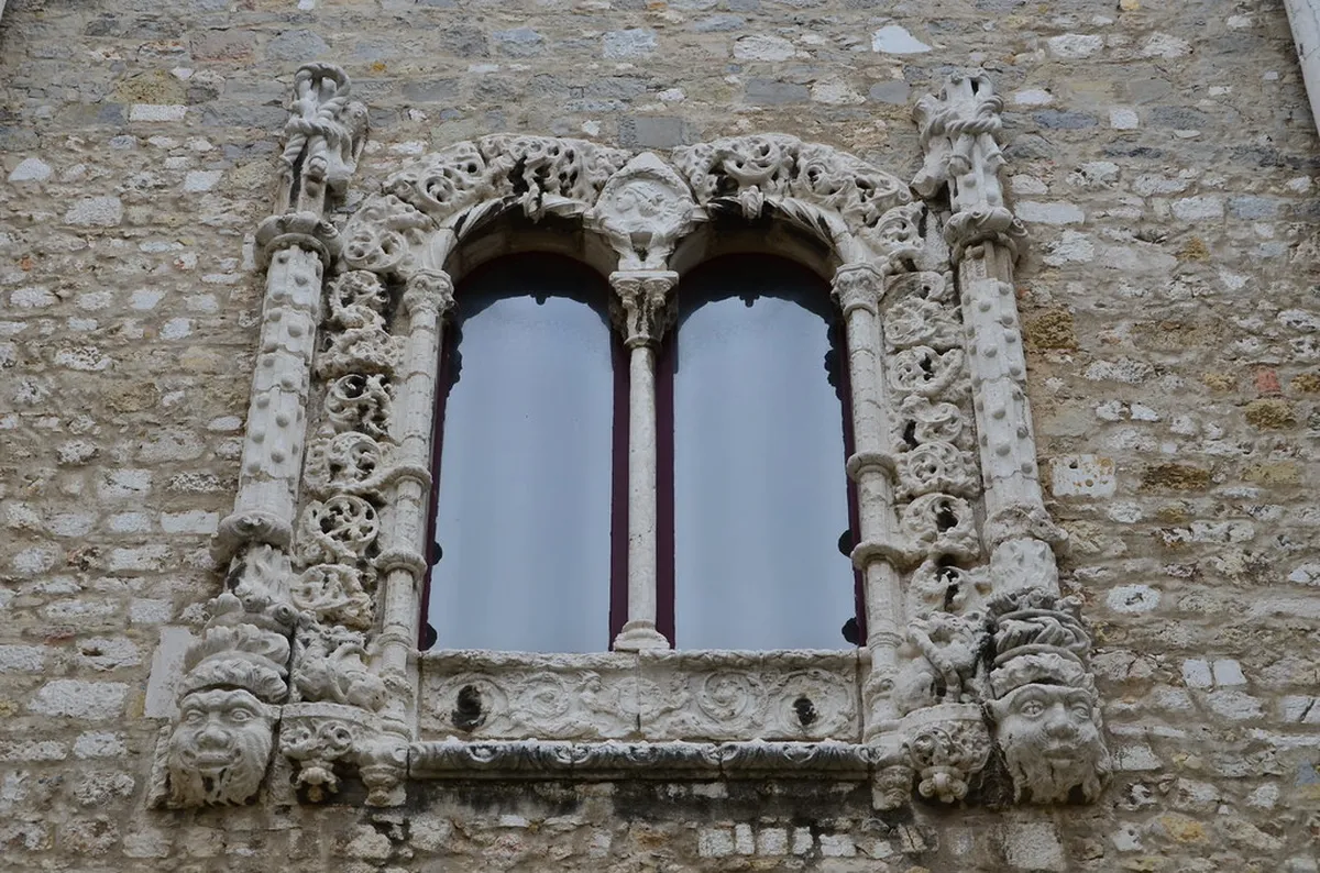 The skeletal Gothic arches of Carmo Convent ruins rising against the Lisbon sky, a haunting reminder of the 1755 earthquake