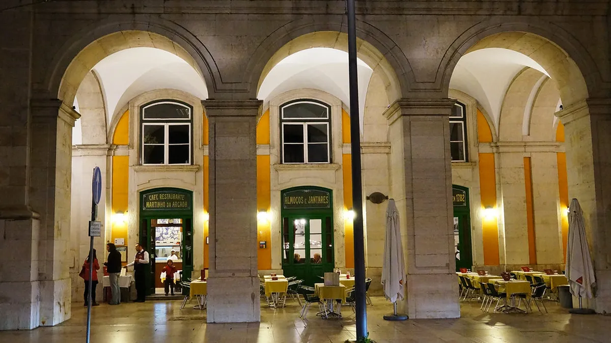The grand arched arcade of Martinho da Arcada in Lisbon, the oldest cafe in the city set within Praça do Comércio