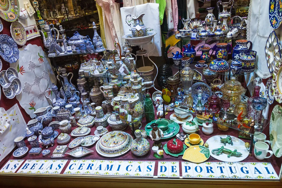 Lisbon artisan shop window displaying hand-painted Portuguese ceramics and traditional decorative tiles for sale