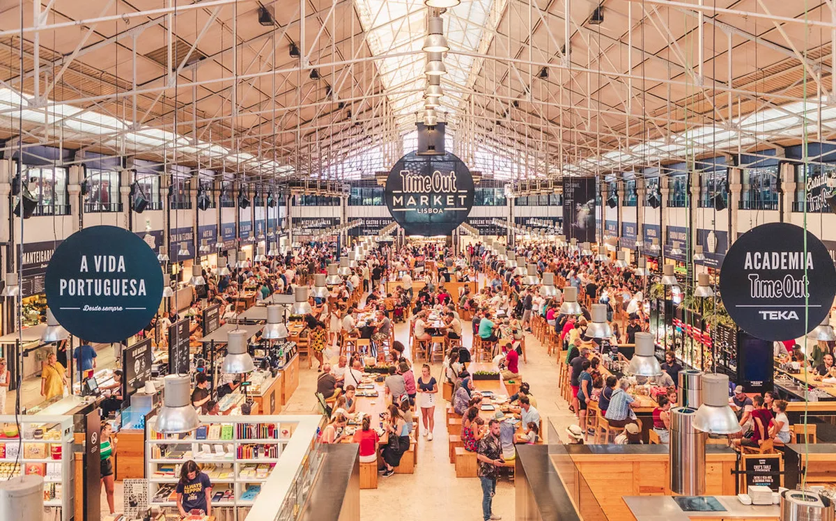 Shoppers browsing cork goods and souvenirs at a Lisbon Baixa street market stall
