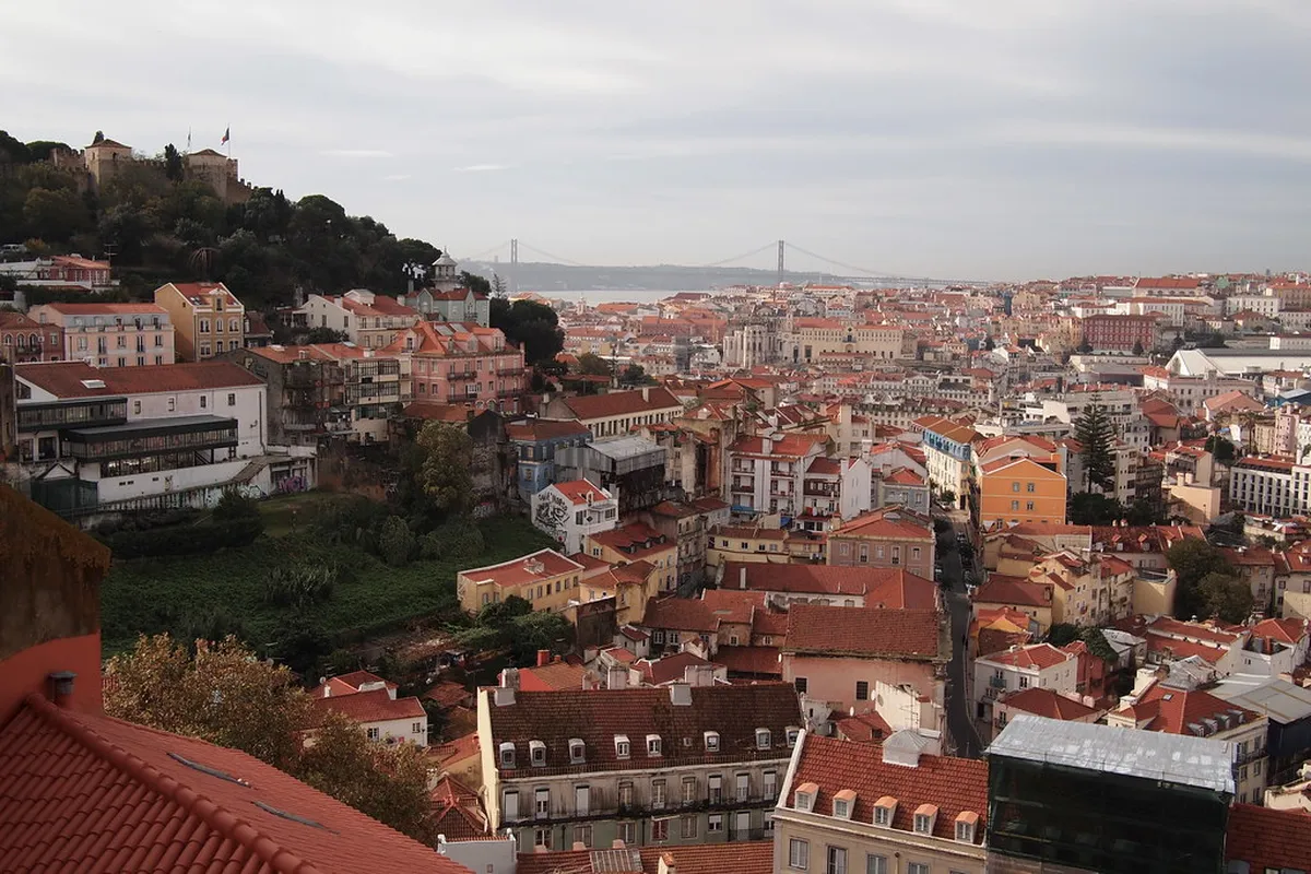 Panoramic view from Miradouro da Graça across Lisbon rooftops toward the Tagus river and São Jorge Castle