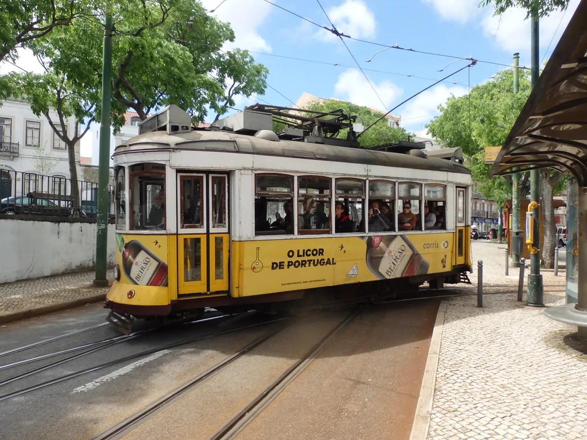 Historic Tram 28 winding through narrow Lisbon streets toward the hilltop Graça district