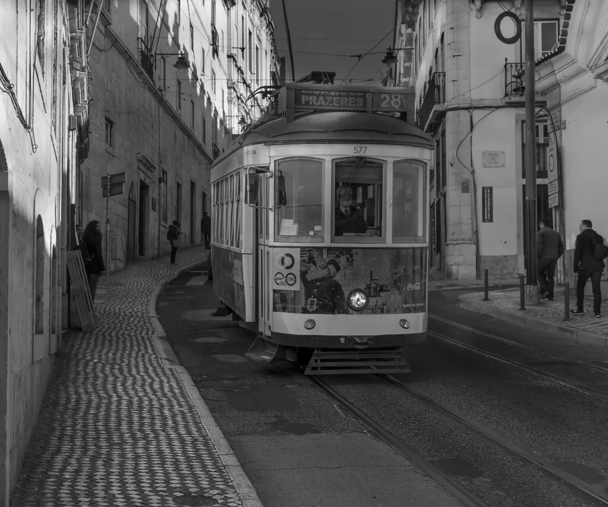 Bairro Alto Lisbon narrow street lit up at night with people dining outside at late-night restaurants