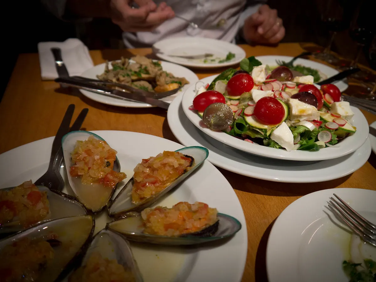 Traditional Lisbon petiscos spread with cured meats, olives, and bread served at a late-night tasca