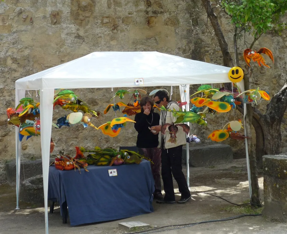 Lisbon street market stalls with colourful goods and browsing locals in a lively historic neighbourhood