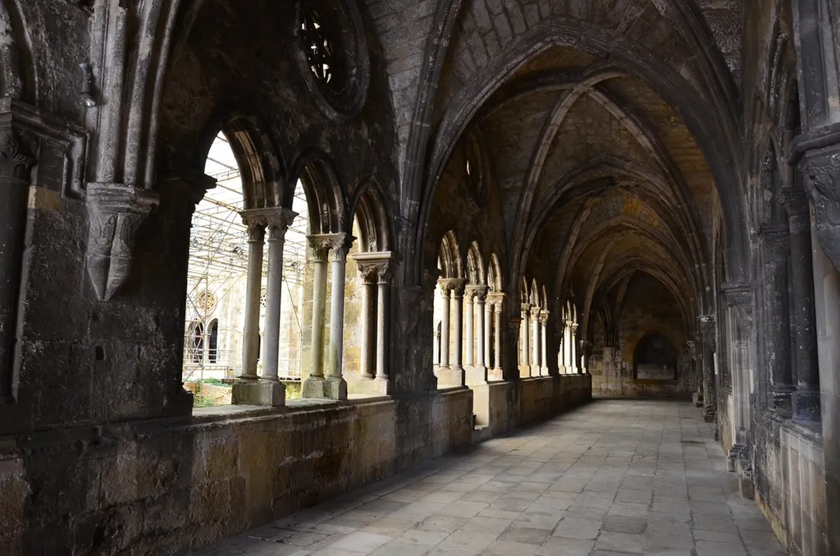 Lisbon Cathedral Gothic cloister with arched stonework and archaeological excavation site visible below