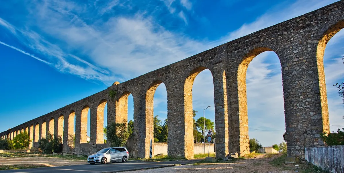 The iconic Águas Livres Aqueduct arches stretching across the Alcântara valley in Lisbon, Portugal