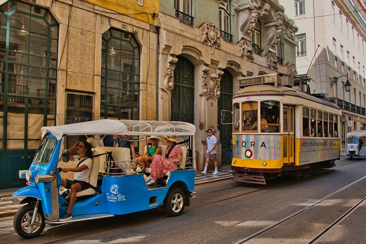 Lisbon Tram 28 running along a historic narrow street in the early morning light
