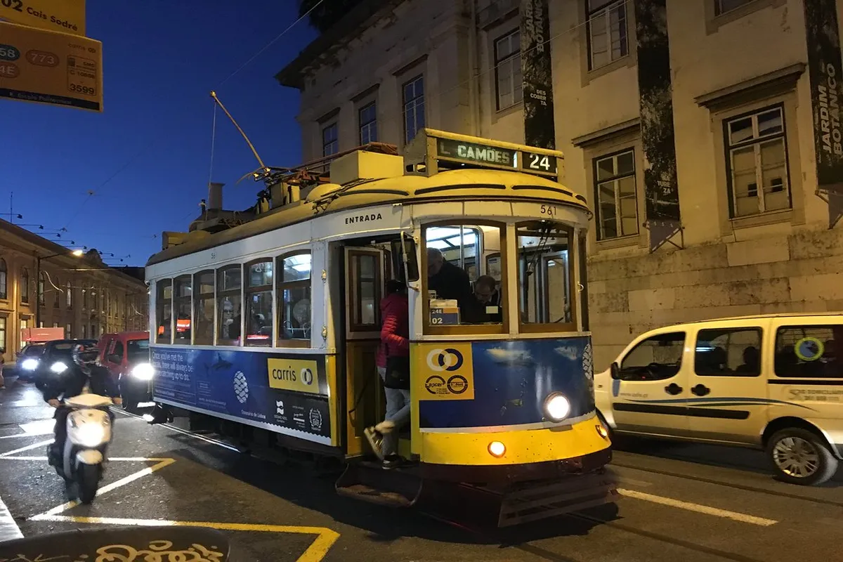 Crowded Lisbon tram 28 carriage on a busy afternoon at a historic stop in Alfama